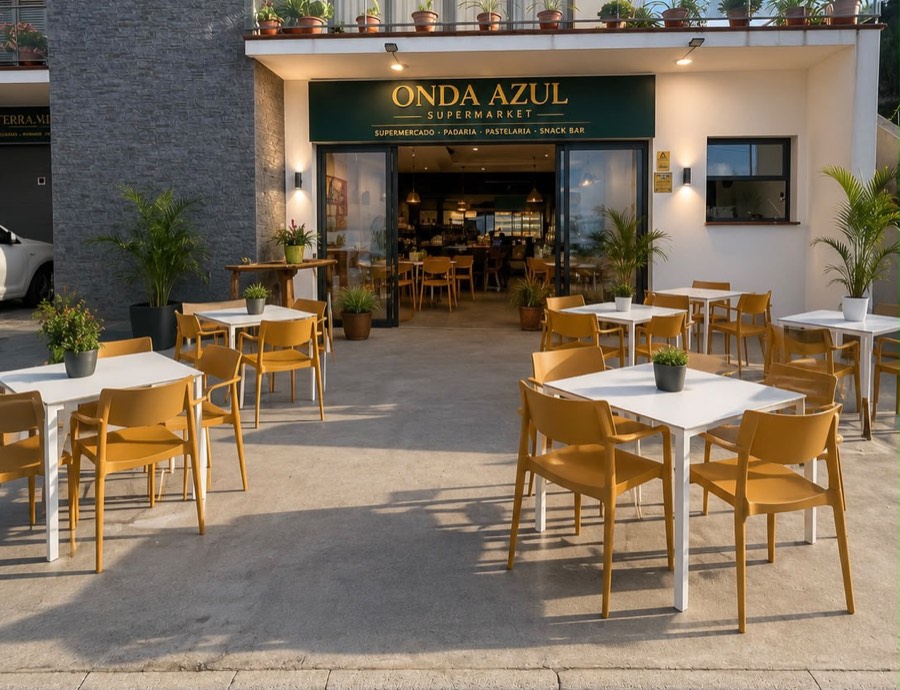 A entrada da Onda Azul: letreiro verde e dourado, mesas e cadeiras amarelas na esplanada