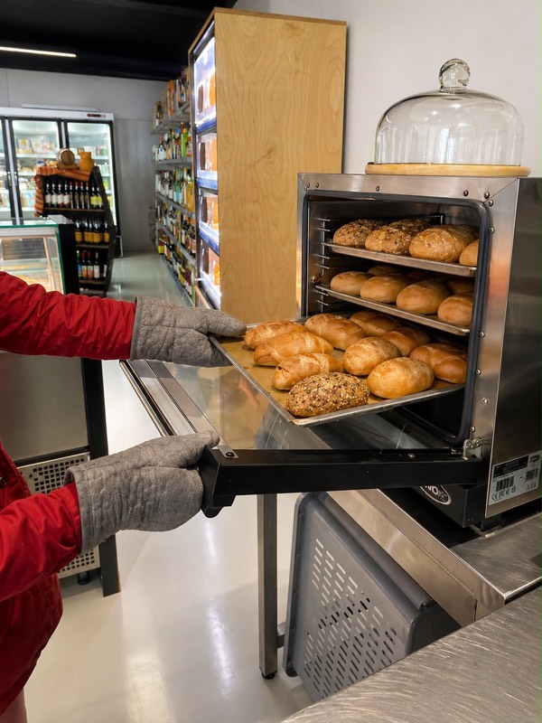 Tabuleiro de pão acabado de sair do forno, ainda nas luvas de quem o tirou