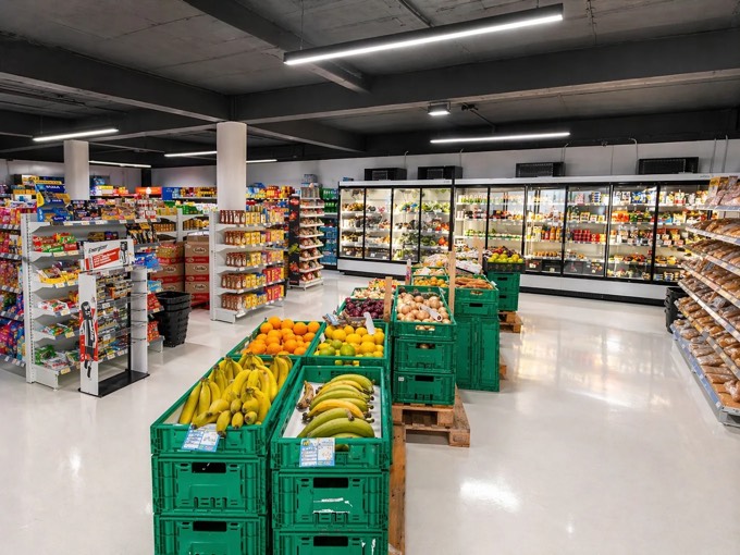 Caixas verdes com banana, laranja e limão no meio da loja